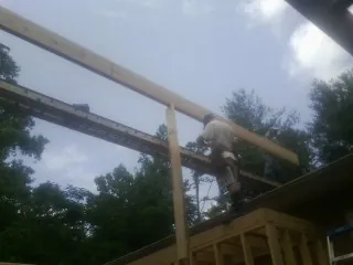 Carpenter setting a ridge beam over a new addition frame — Ice Dam Removal by Roofing Brothers in Harpers Ferry