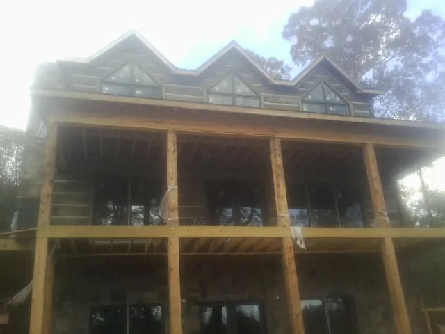 Dormers and porch framing on a large log home under construction — Roof Coating work by our crew in Harpers Ferry