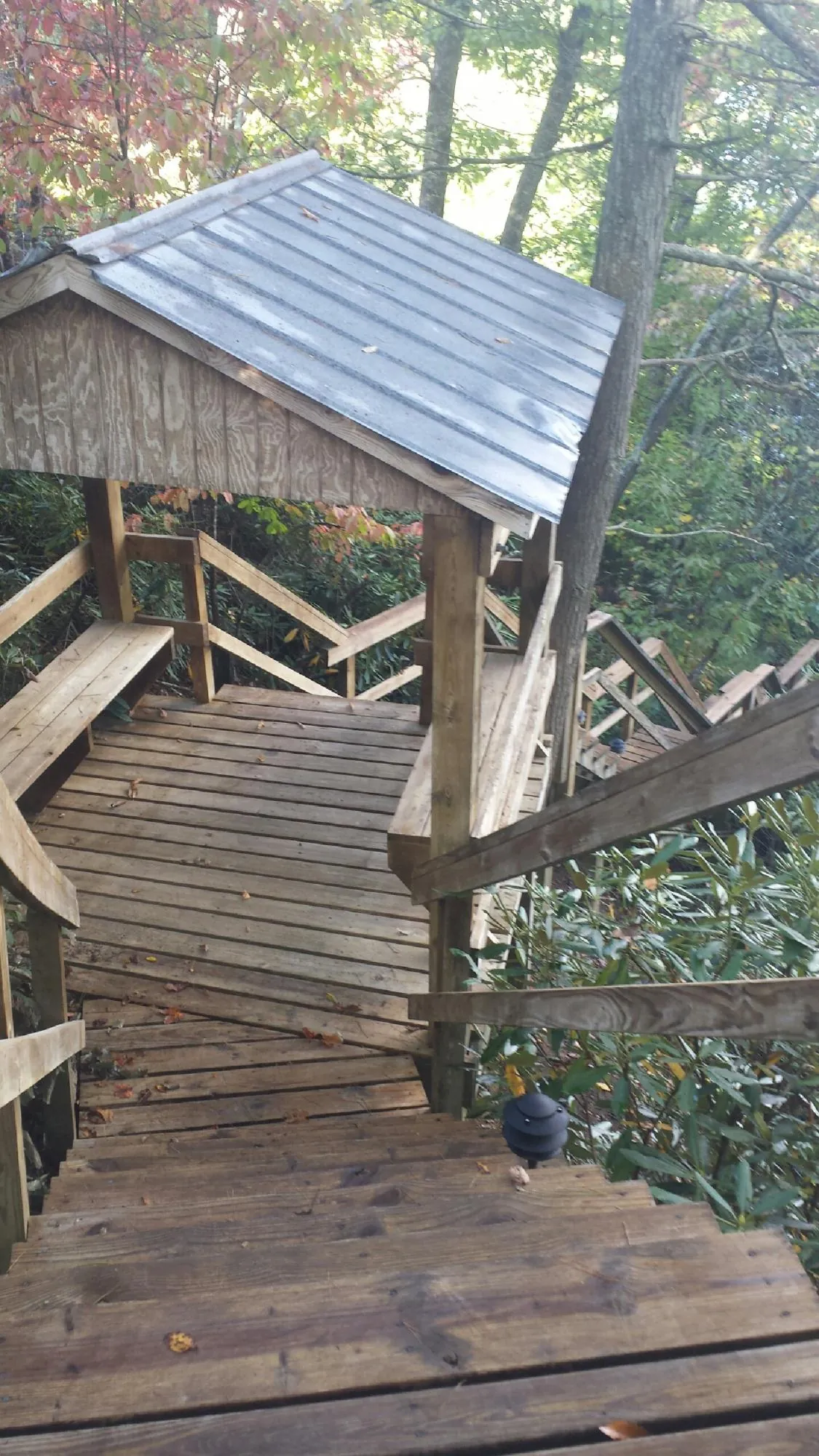 Metal roofed shelter over wooden steps on a wooded walkway — Skylight Repair & Installation work by our crew in Harpers Ferry