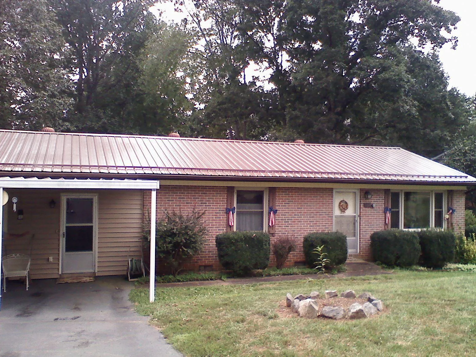 Bronze metal roof and carport on a brick ranch home — Roof Repair work by our crew in Harpers Ferry
